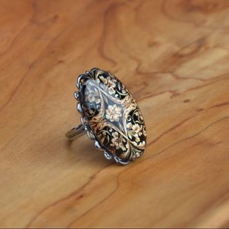 Modni prstan s kovinsko osnovo in stekleno kapljico in baročnim vzorcem