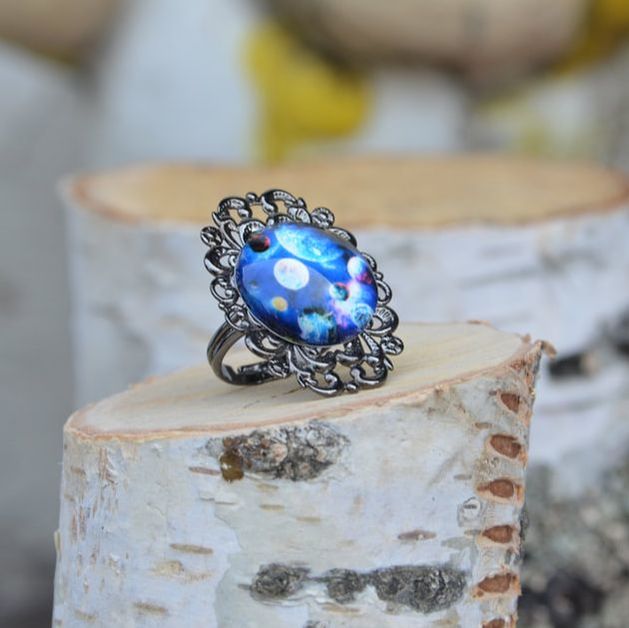 Modni prstan s kovinsko osnovo in stekleno kapljico z modrim vzorcem planetov