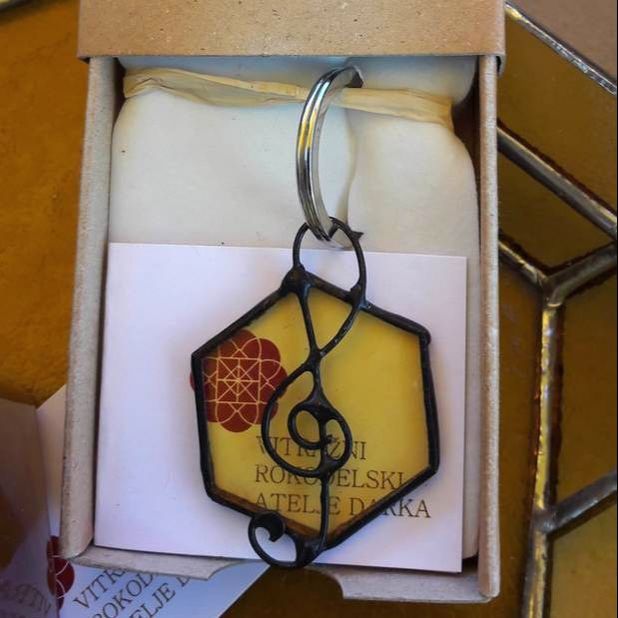 Stekleni obesek za ključe s šestkotnim stekelcem medene barve in okrasom violinskega ključa